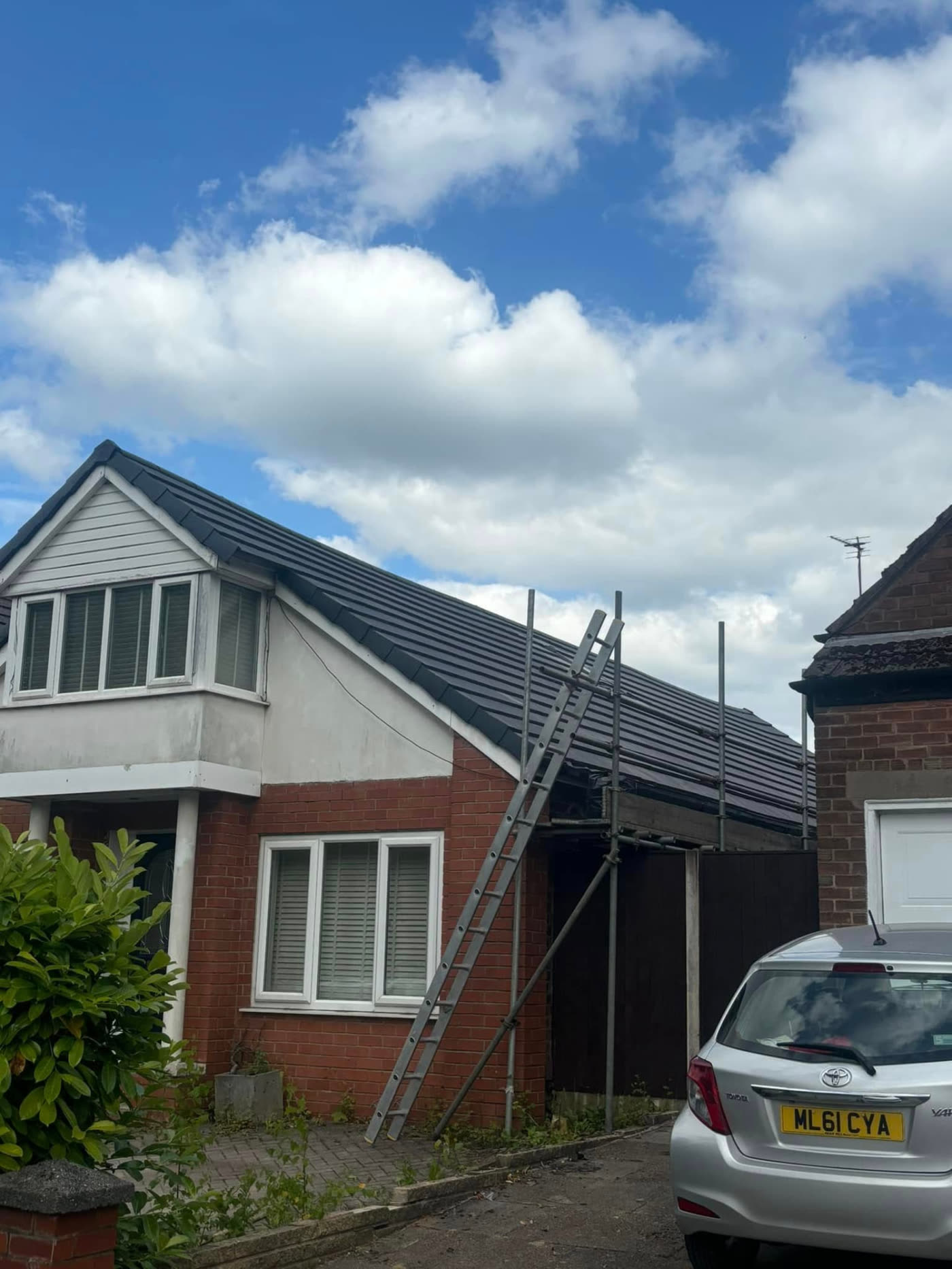 Completed anthracite grey tiled roof with dry verge and ridge on a detached house